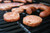 sausage patties and sausage links cooking on a grill